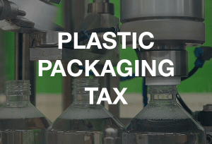 Plastic bottles being manufactured with the words 'Plastic Packaging Tax' overlaid in white
